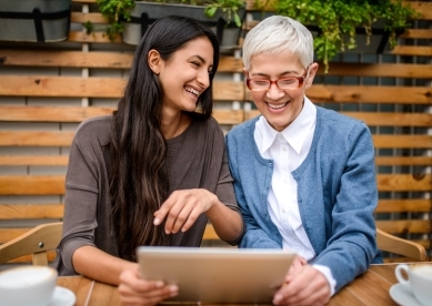 Two happy smiling women using digital tablet 